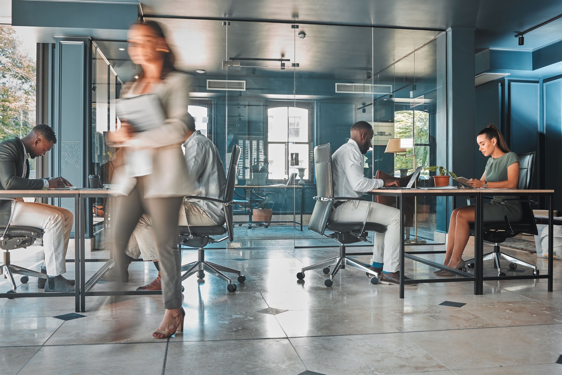 Work process of busy corporate team of business people working at startup marketing company, planning email on laptop and sitting at desk in office. Blur of employees, workers and businesspeople
